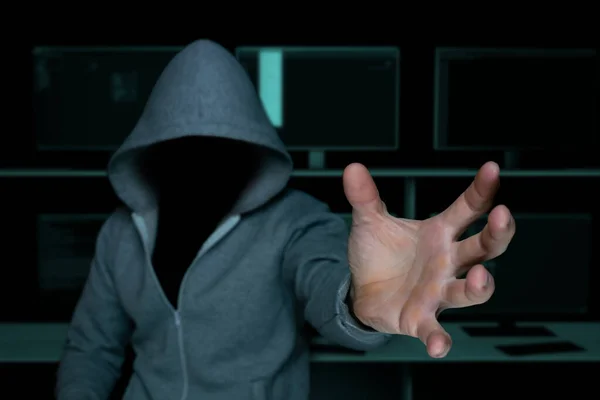 unknown hacker in the hood, pulls his hand to commit theft