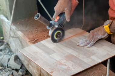 Karanlık Latin bir adam çömlek kesmek için bir makine kullanıyor. Kesik seramik üzerinde inşaat makinesi