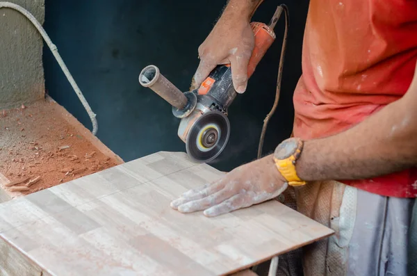 Karanlık Latin bir adam çömlek kesmek için bir makine kullanıyor. Kesik seramik üzerinde inşaat makinesi