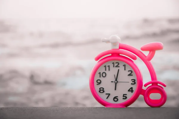 Розовые часы на песке — стоковое фото