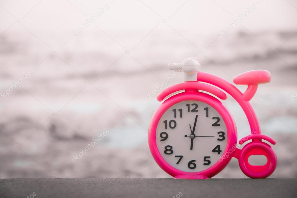 Pink clock on sand