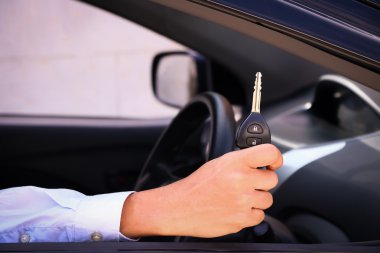 İş adamı gülümseyen gösteren anahtarı