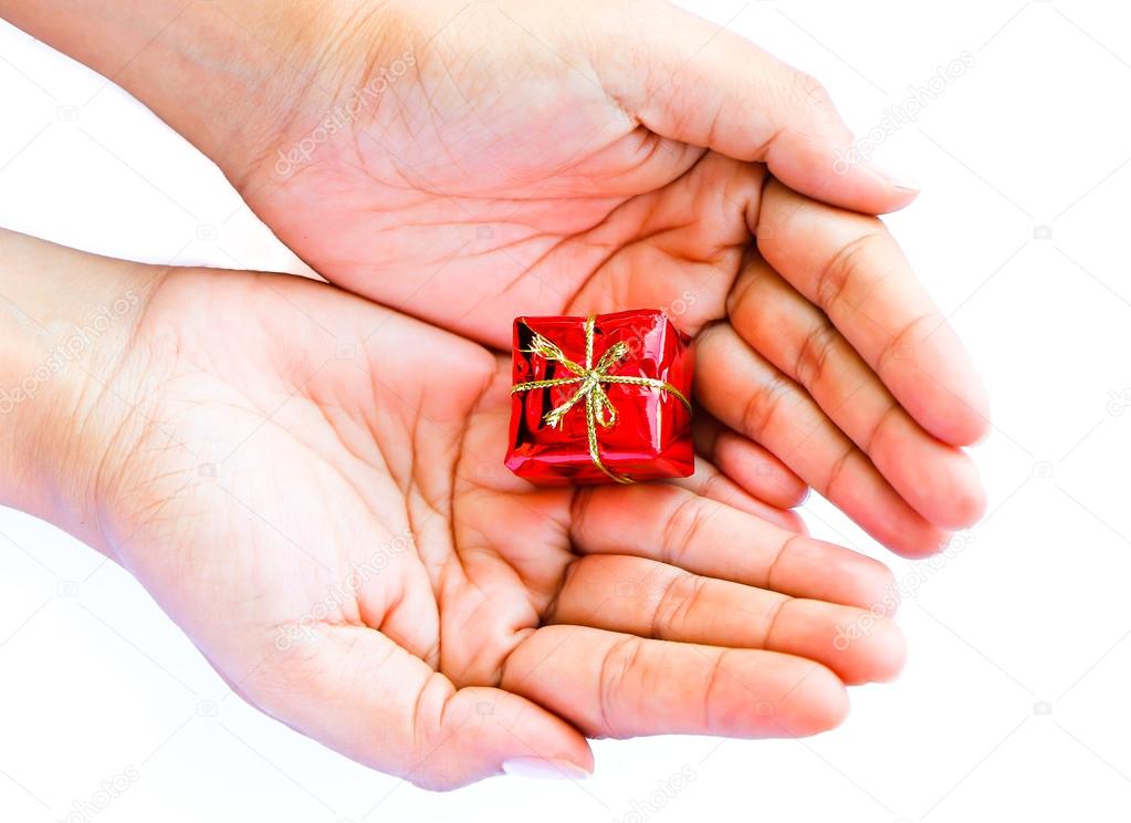 Human hand holding small red gift box
