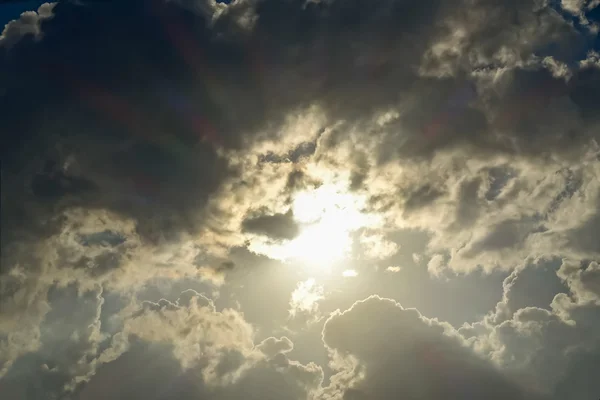 Donkere wolken hemel met zon — Stockfoto