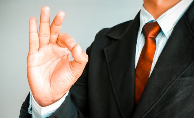 İş adamı kırmızı kravat Tamam gösterilen takım elbiseli