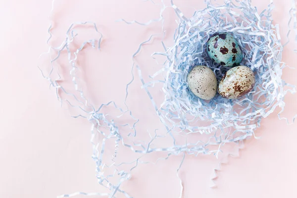 Easter quail eggs and nest on pink background. Easter card. Top view. — Stock Photo, Image