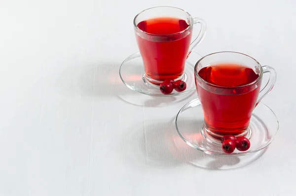 Czerwona Herbata Ziołowa Przezroczystych Dwóch Filiżanek Jagodami Głogu Porannym Słońcu — Zdjęcie stockowe