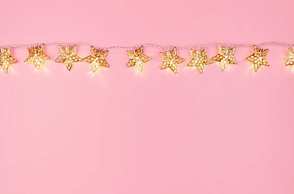 Christmas Glowing Golden Stars Garland Soft Light Pastel Pink Background — Stock Photo, Image