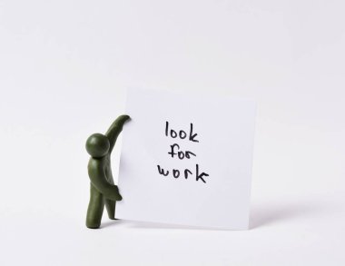 Üzerinde iş ararken yazılan bir posteri tutan bir adamın esmer figürü. İşsizlik kavramı. Boşluğu kopyala.