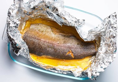 Cam bir kabın içinde alabalık pişiyor. Tatil konsepti, doğum günleri. Düz yat. Boşluğu kopyala.