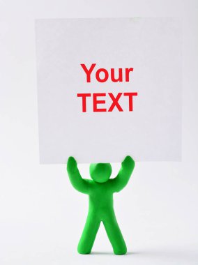 Plastik bir adam figürü beyaz bir poster tutuyor. Üzerinde senin metnin için bir yer var. Tasarım için boş, tasarım için. Boşluğu kopyala.