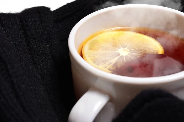 Bufanda negra con taza blanca con té caliente y limón. concepto de comodidad y profilaxis contra los resfriados, así como la comodidad en el clima frío. — Foto de Stock