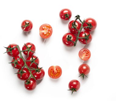 Bir dalda parlak kırmızı kiraz domatesleri ve beyaz masa arkasında tek başına. Boşluğu kopyala.