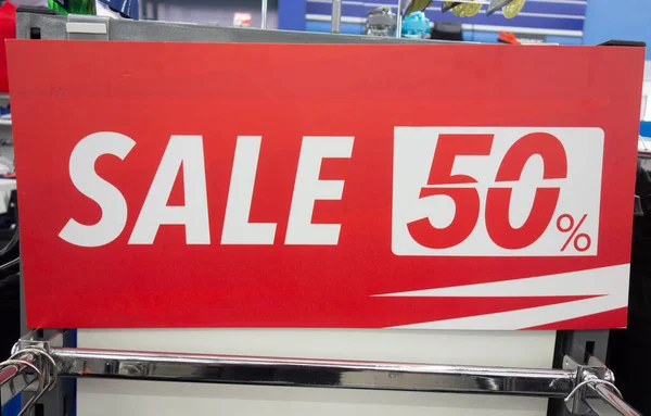 red poster on which a 50 percent discount is written in white letters. concept of discounts in stores, gifts for Christmas and birthday. copy space.
