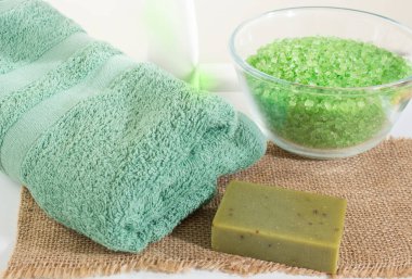 Banyo tuzlu cam kase, zümrüt yeşili. Yanında zeytin sabunu, yeşil havlu ve krema. Rahatlama ve tedavi konsepti. Boşluğu kopyala.