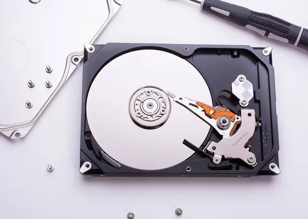 内部からコンピュータのハードディスクを分解し その上にデータが記録され 磁気ヘッドを持つミラーのブランクディスクを使用します 白で隔離されてる 平置き — ストック写真