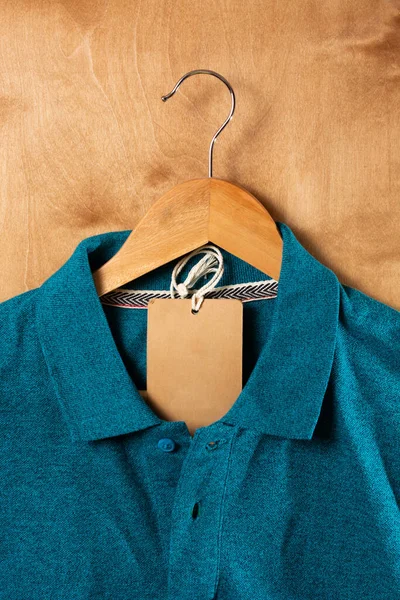 Turkoois Poloshirt Houten Hangers Met Een Bruin Label Houten Achtergrond — Stockfoto