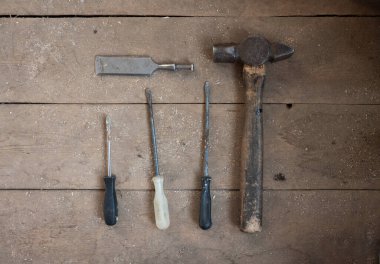 Eski tornavidalar, çekiç ve ahşap arka planda talaşlı bir keski bıçağı..