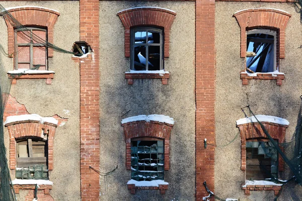 an old brick building with broken windows, through the windows you can see the sky, the roof collapsed. old pinoy factory. copy space.