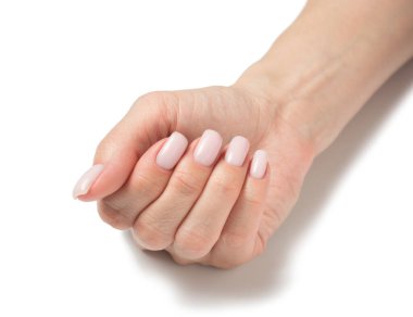 Beyaz arka planda bir kadının elleri. Doğal manikürlü yumuşak eller, temiz cilt. Açık pembe tırnaklar. Boşluğu kopyala.