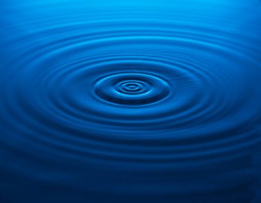 Düşen bir damladan mavi suya dalgalar. Boşluğu kopyala