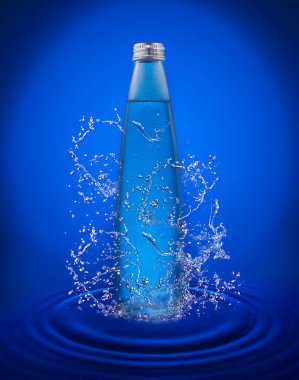 Mavi arka planda cam bir şişe berrak su bir damla ile suyun içinde duruyor. Boşluğu kopyala.