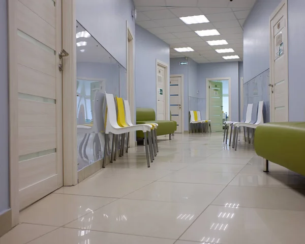 a corridor in a modern clinic, chairs and a sofa for visitors, doctors' offices. copy space.