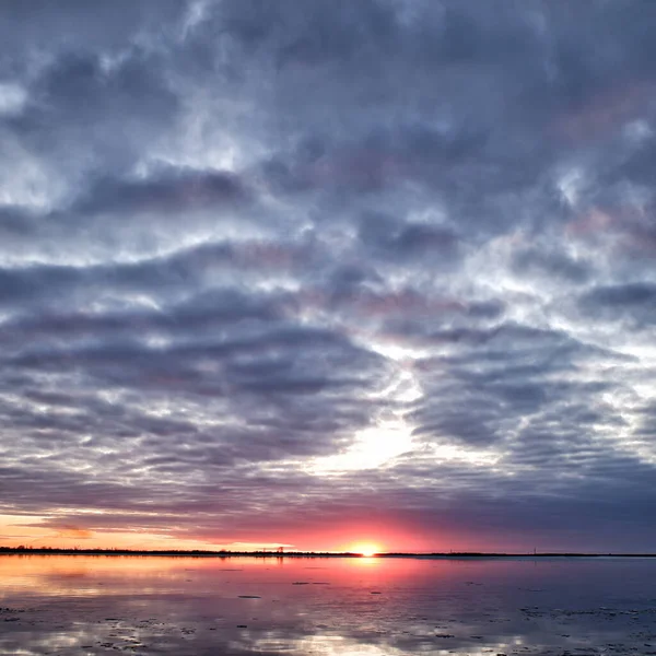 川の夕日は氷から解放され春には流氷が訪れる 暗い雲 — ストック写真