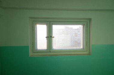 Konut binasının girişindeki merdivenlerde bir pencere var. Güneş camdan içeri doğru parlıyor. sabah vakti.