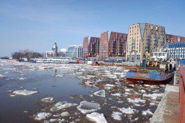 Arkhangelsk, Rusya, 04-23-2021 Kuzey Dvina nehrinin kıyısında modern yerleşim yerleri, kuzeyde ilkbahar, nehirde buz sürükleniyor. güneşli bir gün.