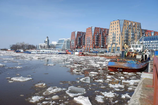 Arkhangelsk, Rusya, 04-23-2021 Kuzey Dvina nehrinin kıyısında modern yerleşim yerleri, kuzeyde ilkbahar, nehirde buz sürükleniyor. güneşli bir gün.