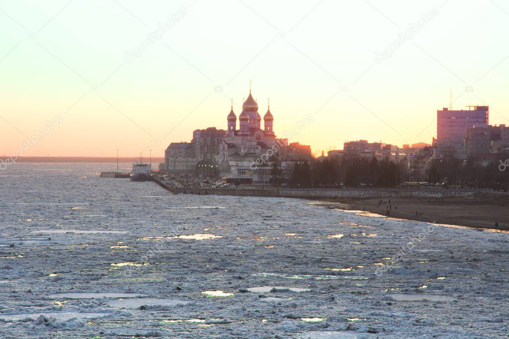 ice drift on the Northern Dvina river against the backdrop of the setting sun and the evening city. copy space.