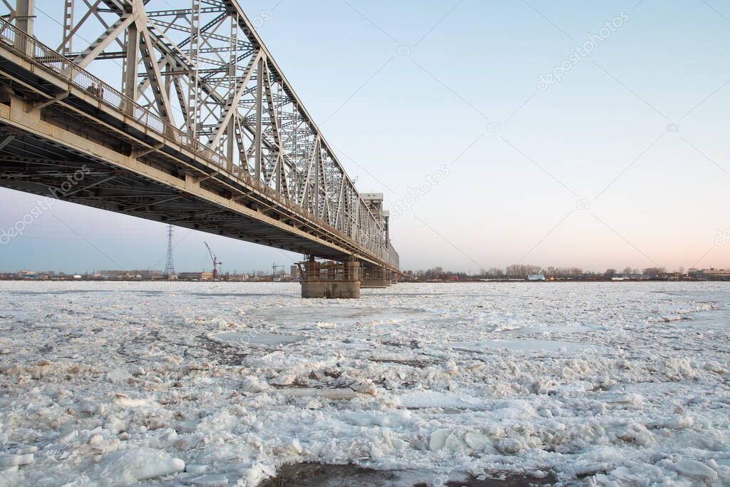bridge over the Northern Dvina river with spring ice drift. evening time. copy space.