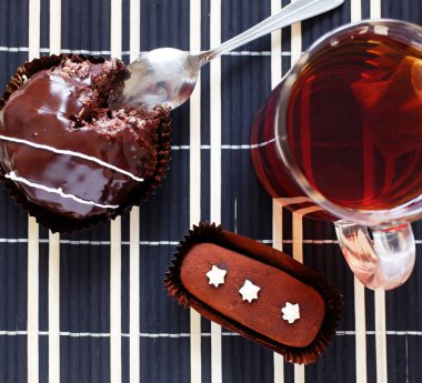 Çay arkaplanda el yapımı çikolatalı pasta ve siyah masa örtüsü. Düz çizgi.