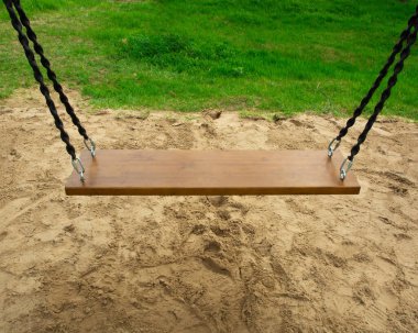 Kum ve otlardan oluşan zincire bağlı ahşap salıncak. tatil ve dinlenme kavramı.