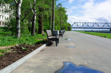Köprünün arka planında yağmurdan sonra Kuzey Dvina nehrinin sıralarıyla dolmuş set..