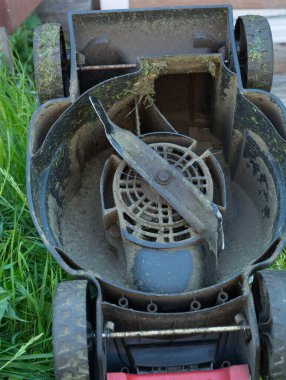 Kırık çim biçme makinesi, eğilmiş bıçaklar. arka bahçedeki çimlerde. Boşluğu kopyala.