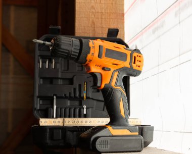 Tornavidayla birlikte çerçeveli bir evin şantiyesinde küçük parçalar ve tahta bir cetvel. İnşaat konsepti yakın plan.