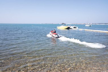 Jet ski süren bir adam deniz kenarında bir gezintiye çıkıyor. dinlenmek ve denizde zaman geçirmek