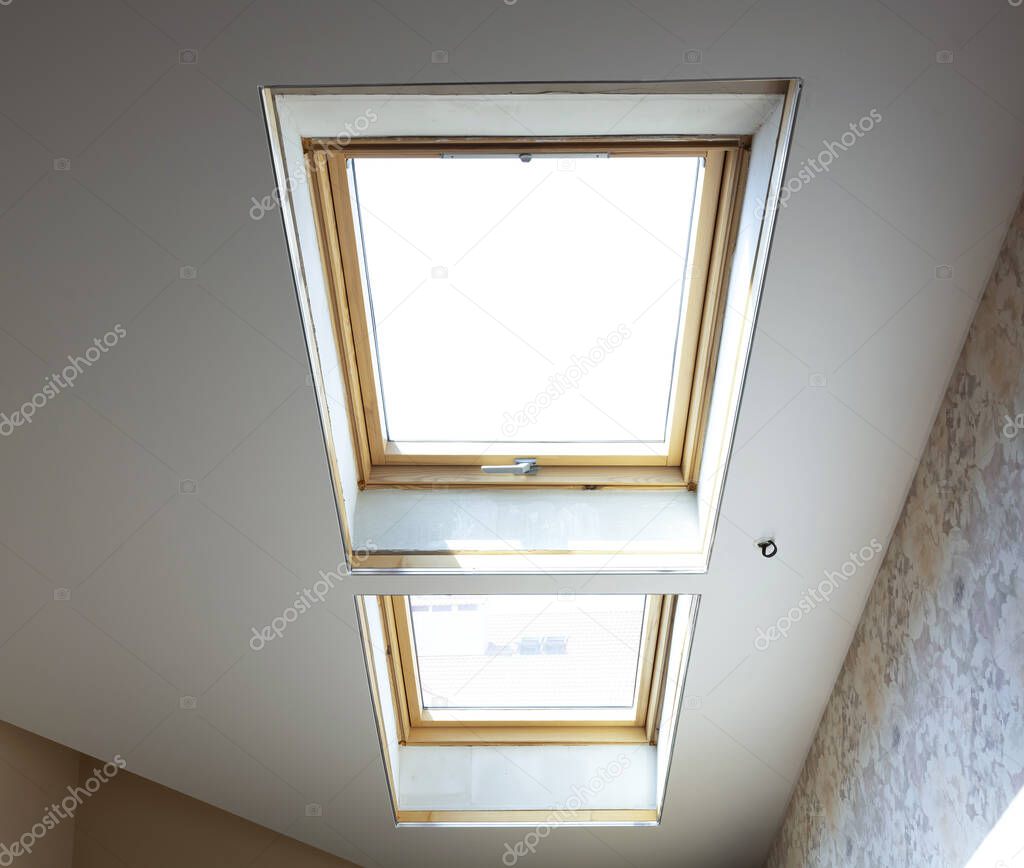 wooden dormer windows in the attic room with bright white light