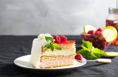 Pastanın üstünde böğürtlen, masada kremalı pasta.