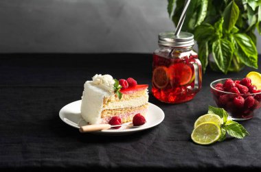 Pastanın üstünde böğürtlen, masada kremalı pasta.