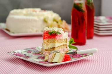 Pastanın üstünde böğürtlen, masada kremalı pasta.