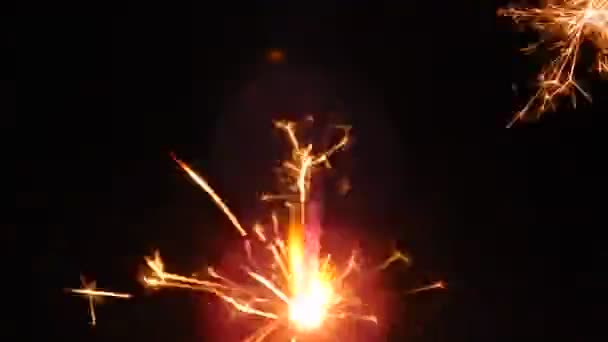 Wonderkaarsen branden vuurwerk op een zwarte achtergrond — Stockvideo