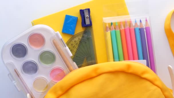 Назад до концепції школи з жовтим рюкзаком та шкільними постачальниками на столі — стокове відео