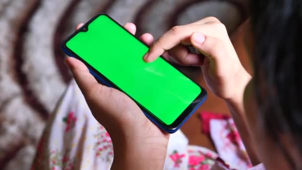 Visão traseira da mão das mulheres usando telefone inteligente em casa — Vídeo de Stock