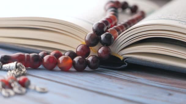 圣书《古兰经》和念珠放在桌上，关门. — 图库视频影像