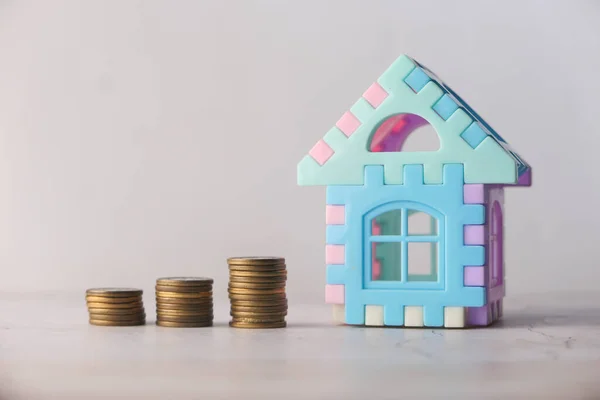 O conceito de conceito de financiamento com pilha de moedas e casa na mesa — Fotografia de Stock