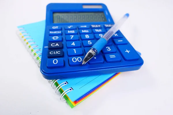 Close up of blue calculator and notepad on color background — Stock Photo, Image