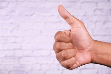 Kadınların elleri beyaz arka planda baş parmak gösteriyor. 